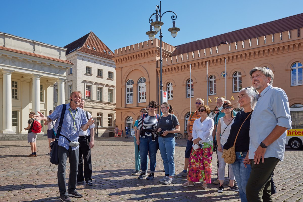 Stadtf&uuml;hrer mit einer G&auml;stegruppe auf dem Schweriner Markt vorm Rathaus. // &copy; Oliver Borchert