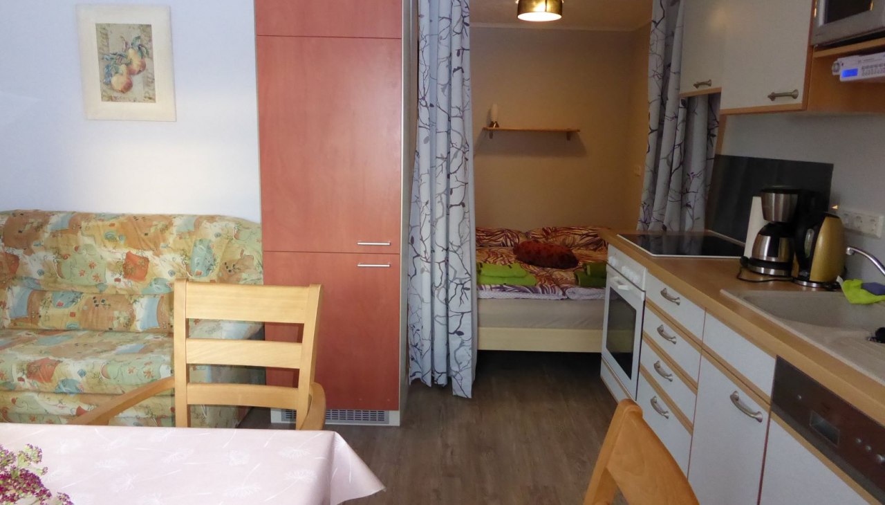 Keuken-woonkamer met slaapnis, eettafel, bank, &copy; Beate Lindstaedt