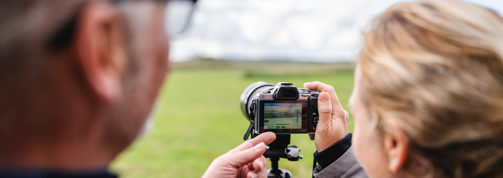 Zwei Personen &uuml;berpr&uuml;fen ein Foto auf der Kamera bei einem Workshop auf Fischland-Dar&szlig;-Zingst.