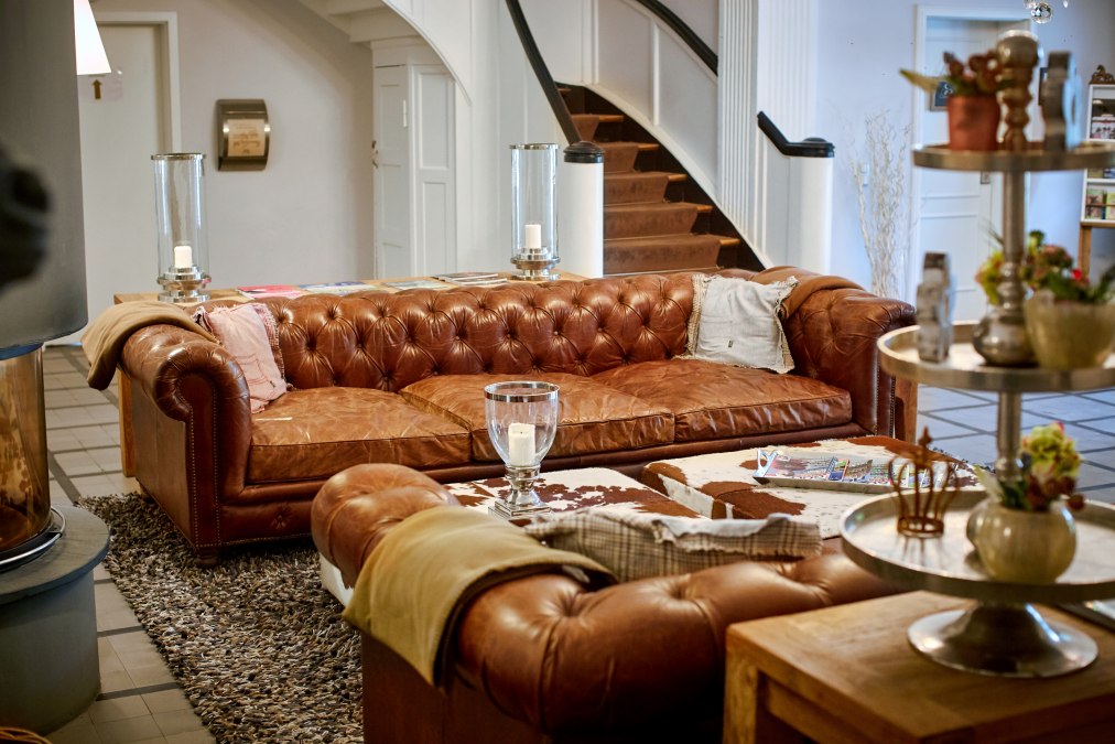 Einladendes Foyer mit Kamin und gemütlichen Sofas auf Gut Vorbeck, © Gut Vorbeck / Thomas Mandt