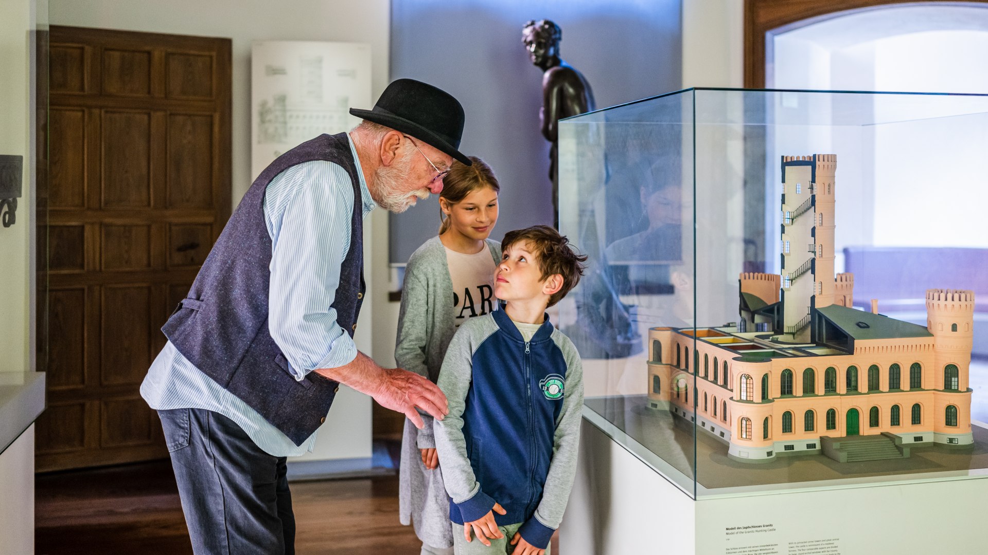 Kinder stehen mit dem Tourführer vor dem Modell des Schloss Granitz // Erst mal einen Blick aufs große Ganze: Das Märchenschloss Granitz im Modell. // © MV-T/Tiemann Kinder stehen mit dem Tourführer vor dem Modell des Schloss Granitz