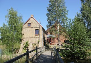 Die Wasserburg Liepen und das Gesindehaus kann man vom Park aus über eine kleine Holzbrücke erreichen., © Burmeister