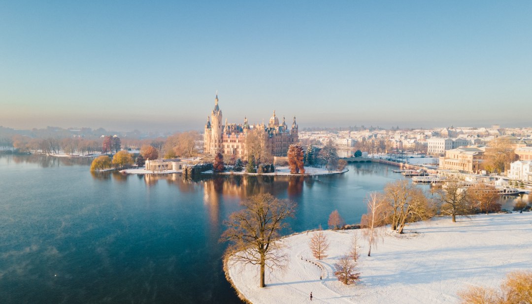 Das Schloss Schwerin in einem Winterkleid aus Schnee am Schweriner See