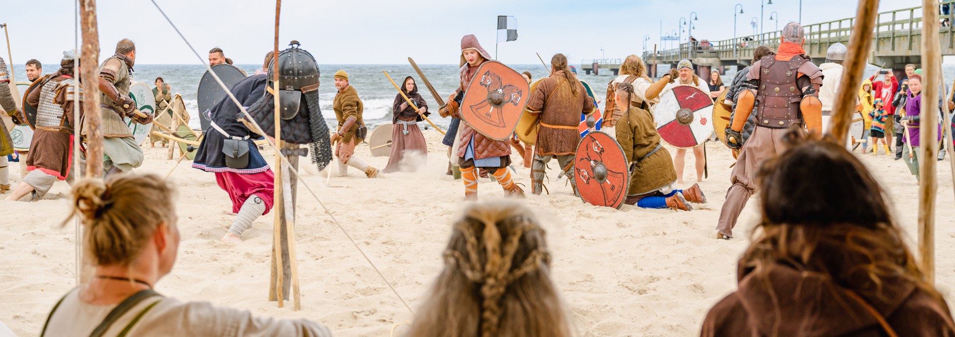 Eine gespielte Wikingerschlacht in G&ouml;hren mit Blick &uuml;ber den Strand auf die Ostsee neben der Seebr&uuml;cke.
