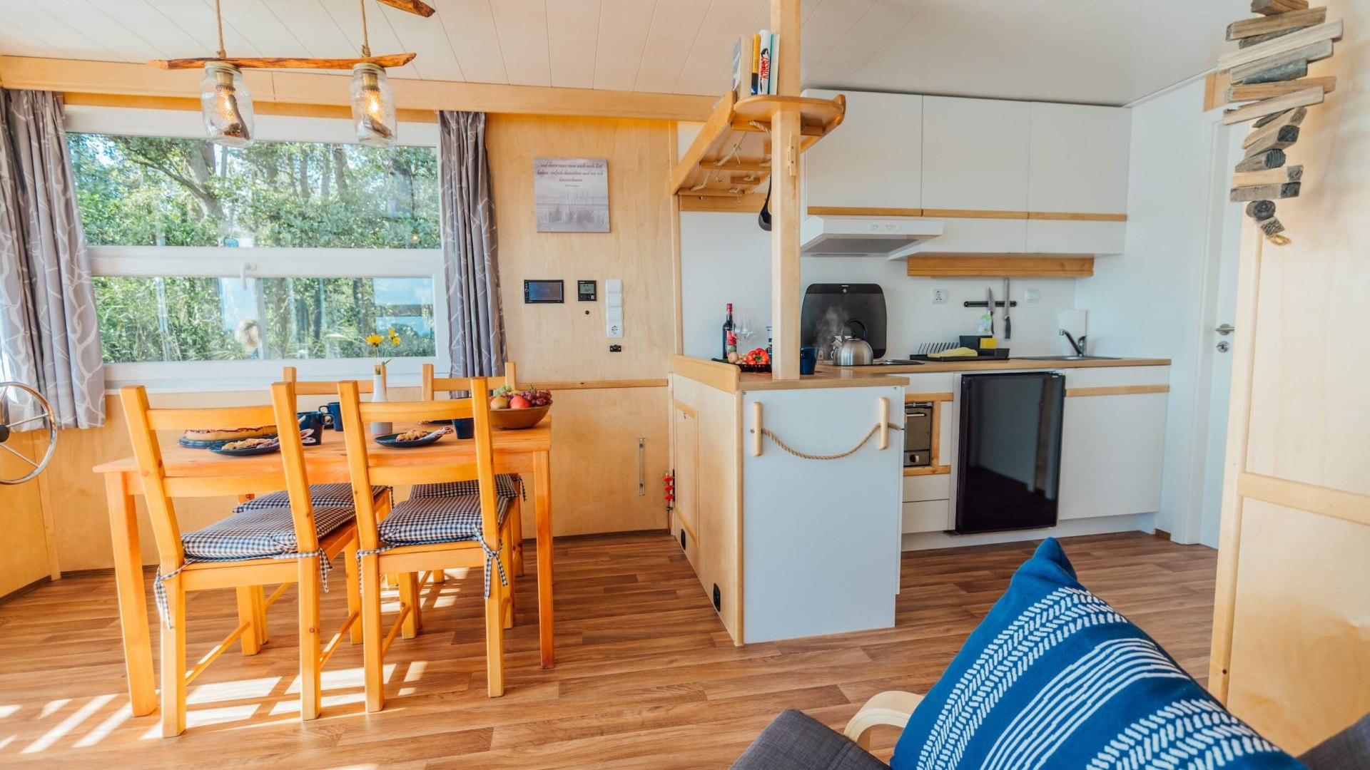 Interieur van een woonboot op de Peene met eethoek, keuken en gezellige inrichting.