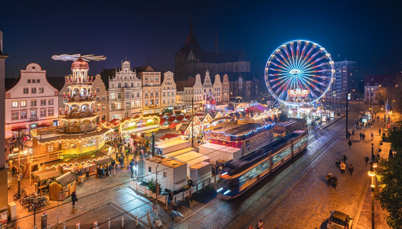 Lichterglanz und festliche Stimmung – der Rostocker Weihnachtsmarkt begeistert mit historischen Fassaden, duftenden Leckereien und einem leuchtenden Riesenrad mitten in der Altstadt., © Erik Gross