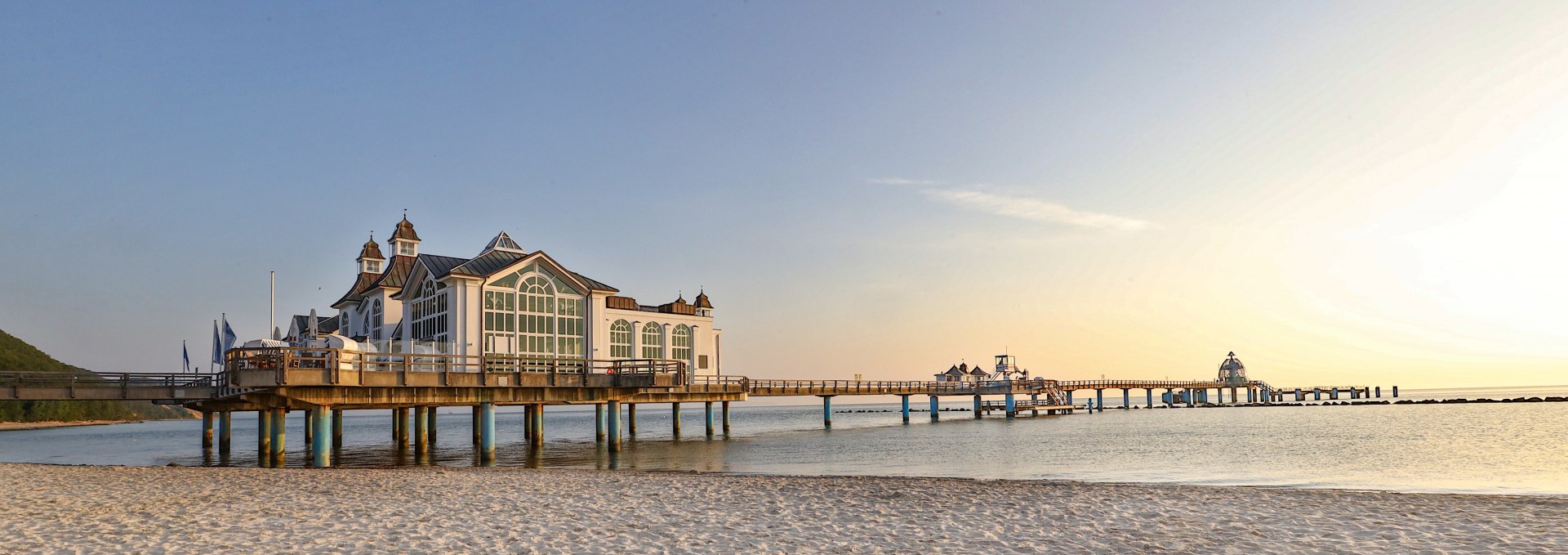 Die Seebrücke im Ostseebad Sellin bei Sonnenaufgang, mit feinem Sandstrand im Vordergrund und ruhiger Ostsee im Hintergrund. // Die Seebrücke im Ostseebad Sellin im sanften Licht der Morgensonne: Ein magischer Ort, der Rügens maritime Schönheit perfekt einfängt. // © MV-T/Gohlke Die Seebrücke im Ostseebad Sellin bei Sonnenaufgang, mit feinem Sandstrand im Vordergrund und ruhiger Ostsee im Hintergrund.