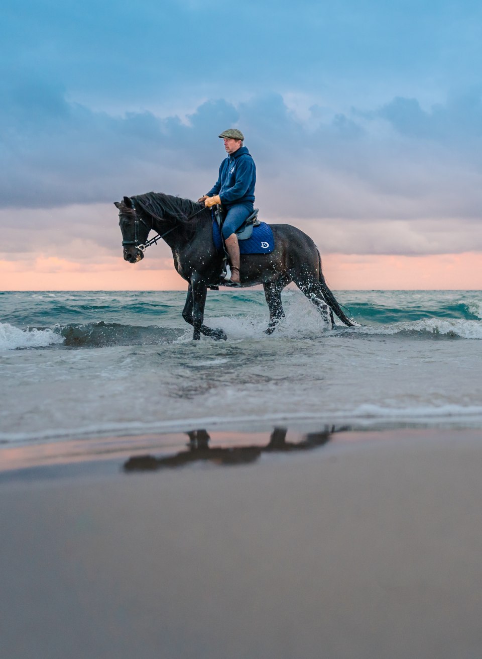 Zwei Reiter auf dem Pferd machen Strandreiten zum Sonnenuntergang an der Ostsee auf der Halbinsel Fischland-Darß-Zingst