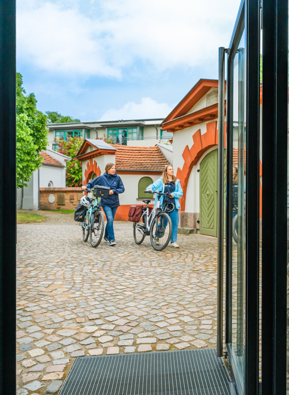 Mutter und Tochter vor dem Eingang zur Ernst Barlach Ausstellung mit Fahrrad // Auf dem Weg zu Ernst Barlach und seinen Skulpturen in Güstrow // © MV-T/Tiemann Mutter und Tochter vor dem Eingang zur Ernst Barlach Ausstellung mit Fahrrad