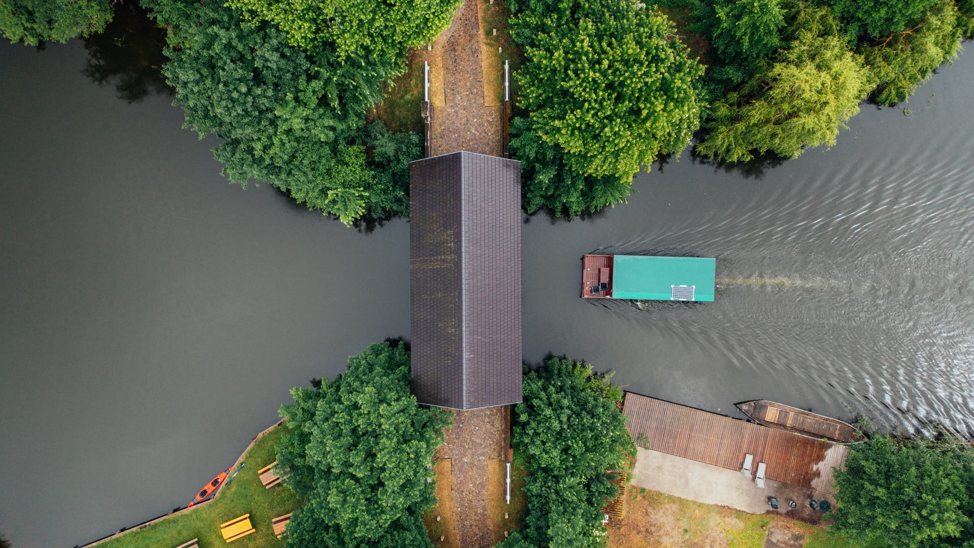 Ahrensberger Hausbr&uuml;cke &ndash; die einzig erhaltene Hausbr&uuml;cke Norddeutschlands. Ein Bild direkt von oben auf die Br&uuml;cke und ein Hausboot f&auml;hrt darunter durch.