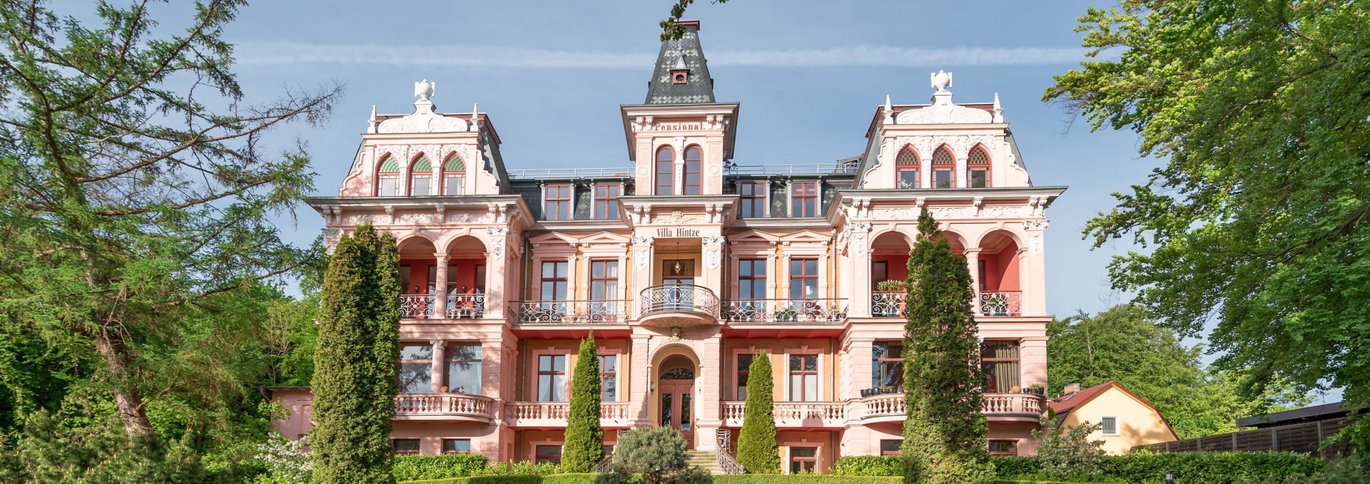 Historische Villa im Stil der Bäderarchitektur auf Usedom mit verzierten Fassaden und gepflegtem Vorgarten.