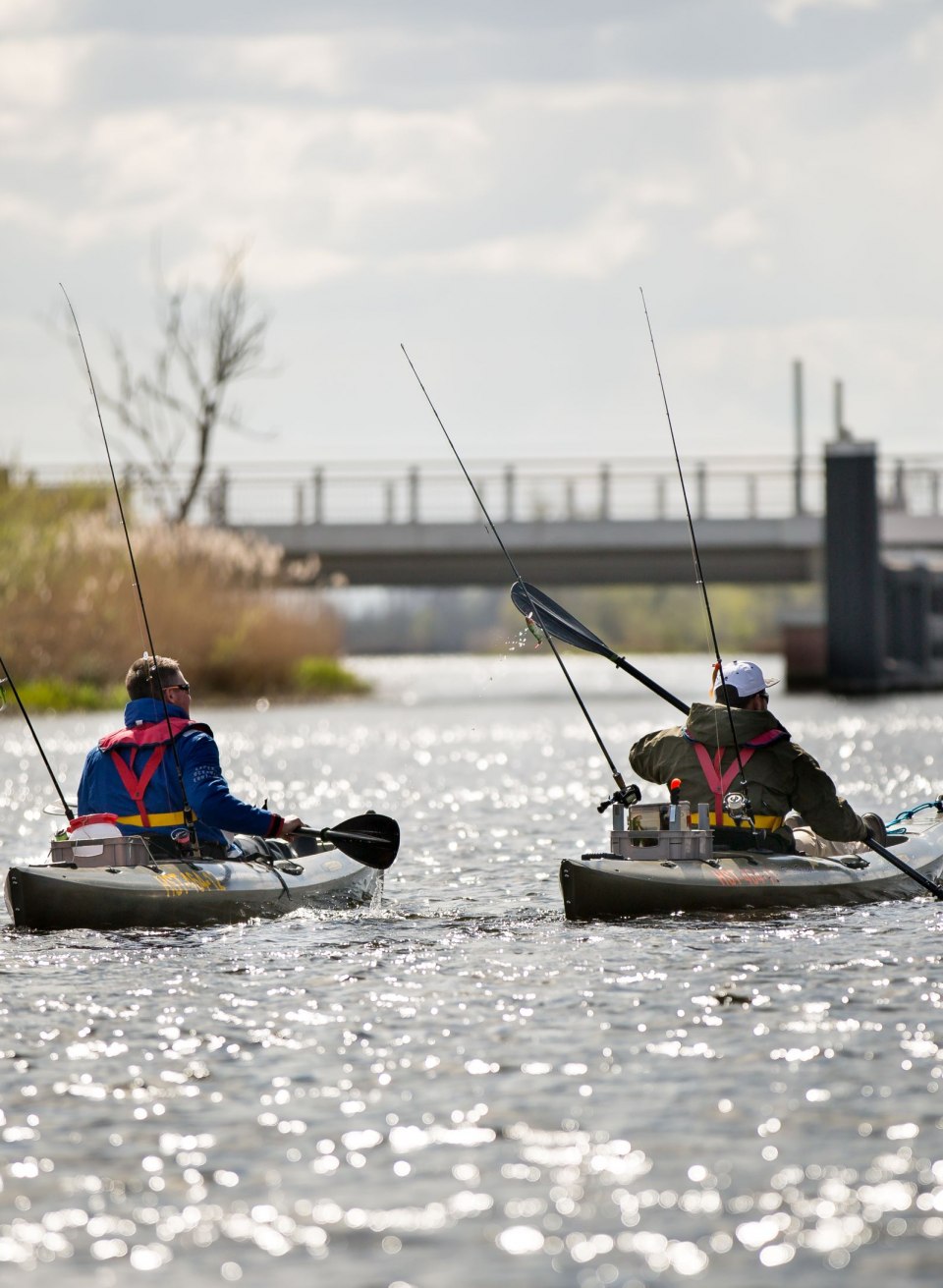 Zwei Angler paddeln in ihren Kajaks die Peene hinunter, während ihre Ruten bereit für den nächsten Fang sind. Die friedliche Atmosphäre auf dem Wasser und das Glitzern der Sonnenstrahlen schaffen eine perfekte Kulisse für eine entspannte Angeltour. // © MV-T/Laeufer Zwei Angler paddeln in ihren Kajaks die Peene hinunter, während ihre Ruten bereit für den nächsten Fang sind. Die friedliche Atmosphäre auf dem Wasser und das Glitzern der Sonnenstrahlen schaffen eine perfekte Kulisse für eine entspannte Angeltour.
