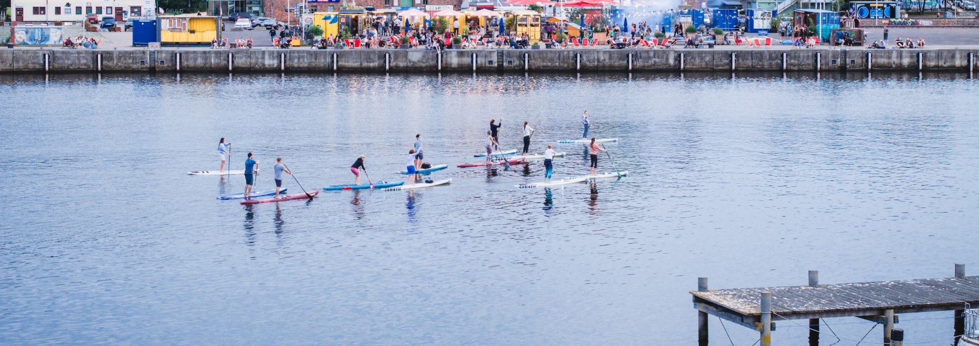 Zum Wasser ist es in Rostock nie weit. Der Hafen liegt mitten in der Stadt &ndash; perfekt, um an der Kaikante zu entspannen oder eine Runde mit dem SUP aufs Wasser rauszufahren! 
