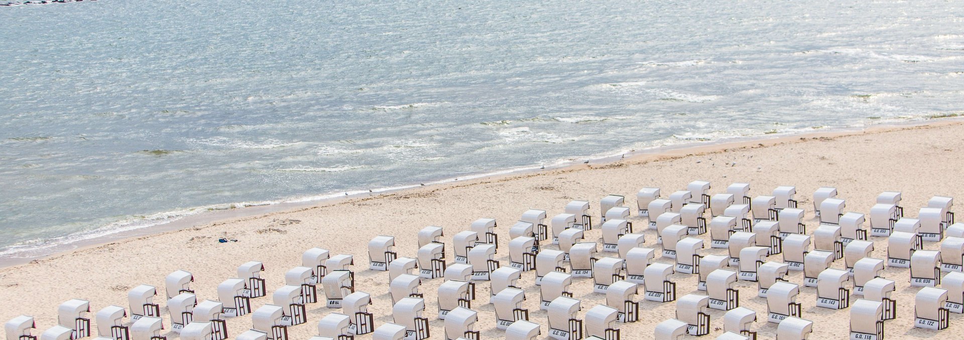 Wie kleine Miniaturfiguren reihen sich weiße Strandkörbe am Selliner Strand aneinander. // © MV-T/Krauss Wie kleine Miniaturfiguren reihen sich weiße Strandkörbe am Selliner Strand aneinander. // © MV-T/Krauss