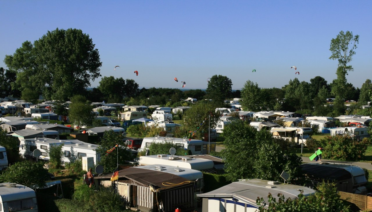 Blick über den Platz im Hintergrund die Kitesurfer auf dem Wasser, © Ferien- und Freizeitpark/Jastrow Blick über den Platz im Hintergrund die Kitesurfer auf dem Wasser, © Ferien- und Freizeitpark/Jastrow