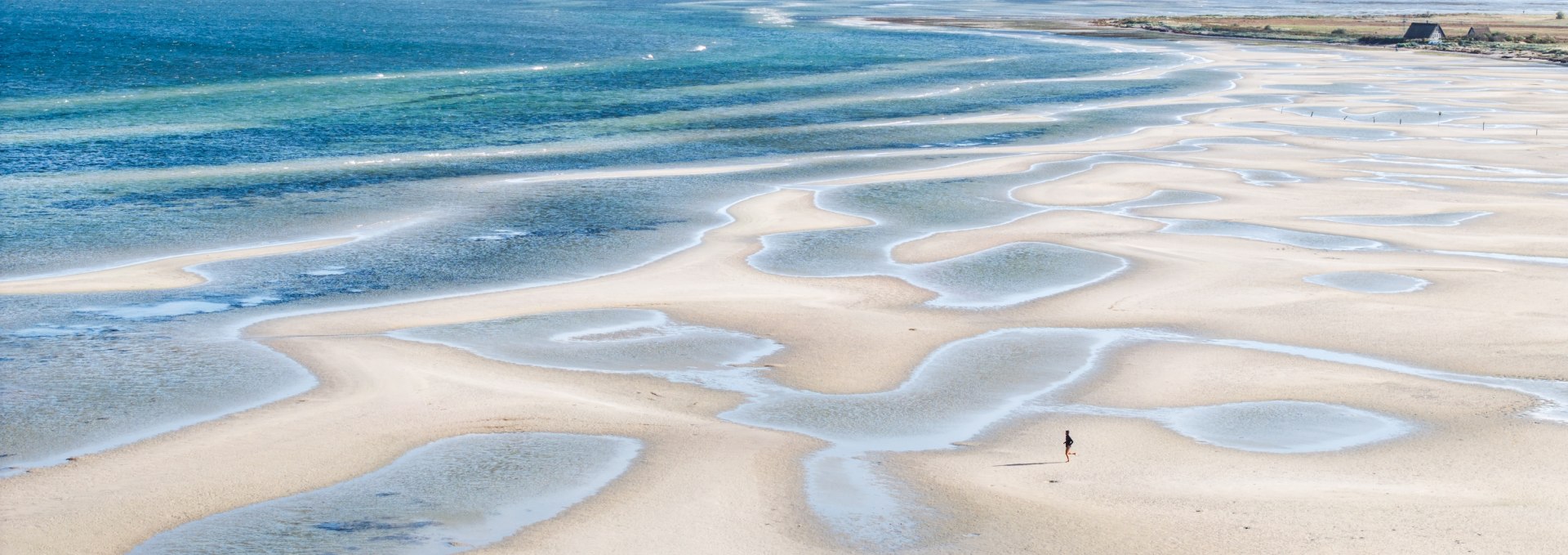 Weitl&auml;ufige Sandb&auml;nke und flache Wasserfl&auml;chen bei Gollwitz auf der Insel Poel, aufgenommen bei Ebbe unter klarem Himmel.