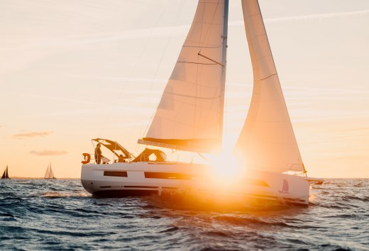 Segelboot mit orangefarbenen Segeln auf der Ostsee vor Warnemünde bei Sonnenuntergang. // Goldenes Licht taucht die Segel in warme Farben – auf der Ostsee vor Warnemünde verschmelzen Horizont und Freiheit. Wind füllt die Segel, Wellen rauschen leise, während die Sonne langsam ins Meer sinkt. // © MV-T/Petermann Segelboot mit orangefarbenen Segeln auf der Ostsee vor Warnemünde bei Sonnenuntergang.