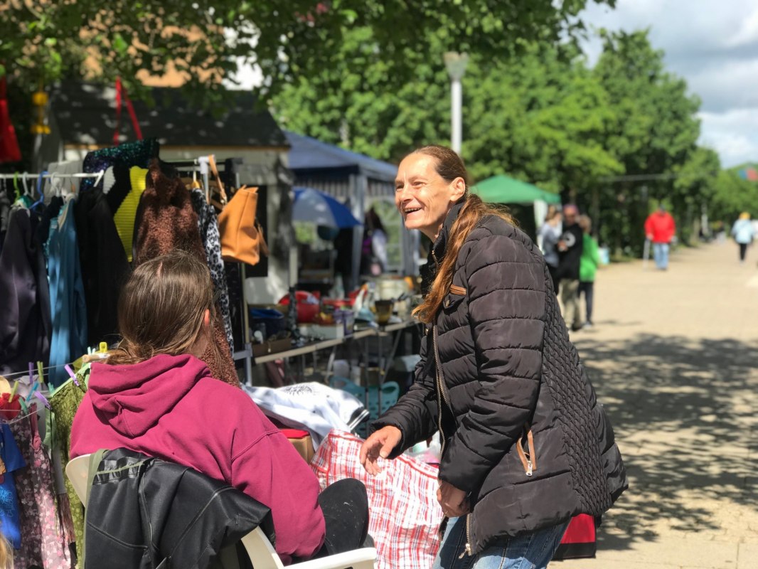 "Een moment vol ontmoetingen: tussen de kledingrekken, zonneschijn en kleine schatten gaat het op onze rommelmarkt niet alleen om kopen en verkopen - het gaat om kletsen, lachen en genieten van elkaars gezelschap." // &copy; LGE-MV
