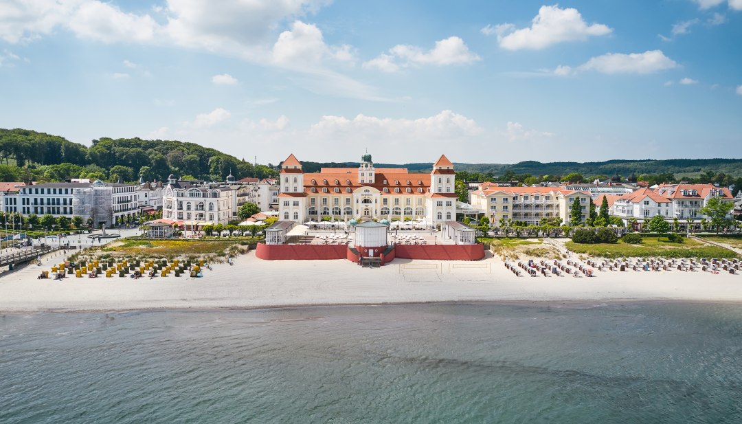Hotel Kurhaus Binz op Rügen vanuit de lucht met uitzicht op het strand vanaf de zee // Hotel Kurhaus Binz op Rügen // © Kurhaus Binz Hotel Kurhaus Binz op Rügen vanuit de lucht met uitzicht op het strand vanaf de zee