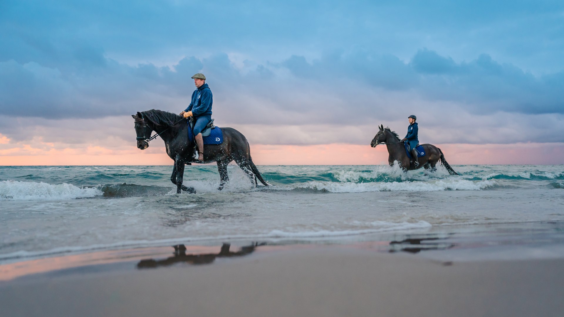 Zwei Reiter auf dem Pferd machen Strandreiten zum Sonnenuntergang an der Ostsee auf der Halbinsel Fischland-Dar&szlig;-Zingst