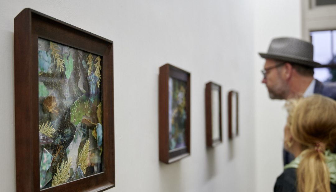 Besucher betrachten während der Veranstaltungsreihe KUNST HEUTE gerahmte Naturcollagen in einer hellen Ausstellung. // Im Rahmen von KUNST HEUTE entdecken Besucher einzigartige Naturcollagen – regionale Kunst hautnah in stilvoller Galerieatmosphäre erleben. // © Thomas Haentzschel Besucher betrachten während der Veranstaltungsreihe KUNST HEUTE gerahmte Naturcollagen in einer hellen Ausstellung.