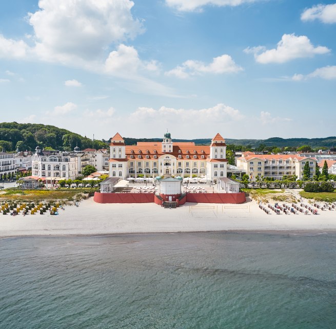Hotel Kurhaus Binz op Rügen vanuit de lucht met uitzicht op het strand vanaf de zee // Hotel Kurhaus Binz op Rügen // © Kurhaus Binz Hotel Kurhaus Binz op Rügen vanuit de lucht met uitzicht op het strand vanaf de zee