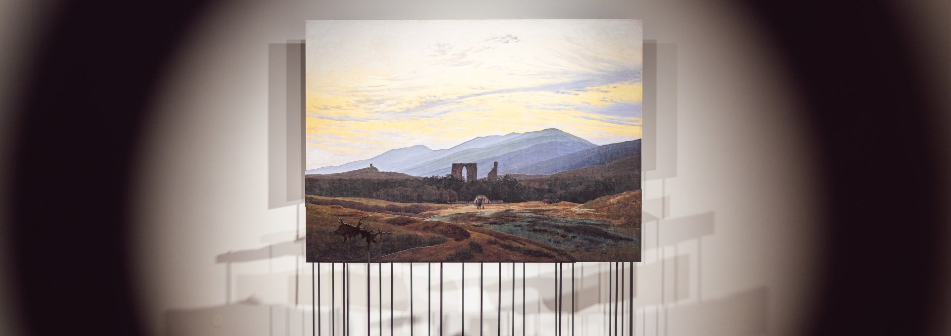 Romantisches Landschaftsgem&auml;lde auf Sockel, durch kreisf&ouml;rmige &Ouml;ffnung fotografiert, im Pommerschen Landesmuseum.