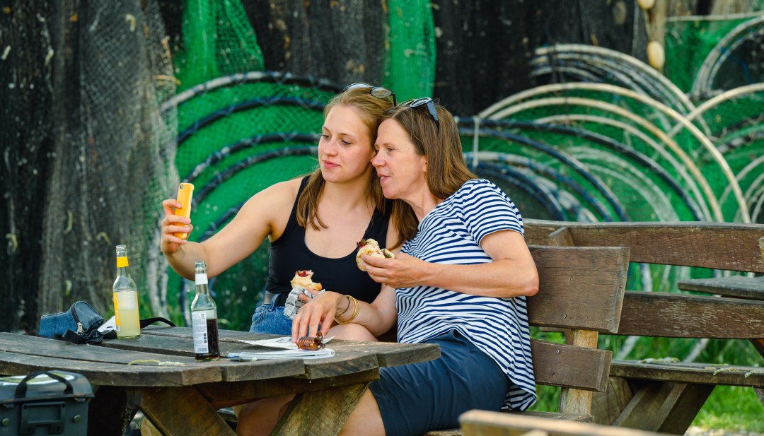 Mutter und Tochter machen Selfie mit Fischbrötchen in Damerow // Selfie mit Fischbrötchen am Fischerhof Damerow // © MV-T/Tiemann Mutter und Tochter machen Selfie mit Fischbrötchen in Damerow