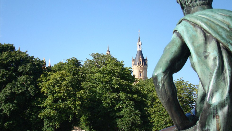 Blick über die Schulter einer Herrschertugend zum Schloss, © Tourismusverband Mecklenburg-Schwerin