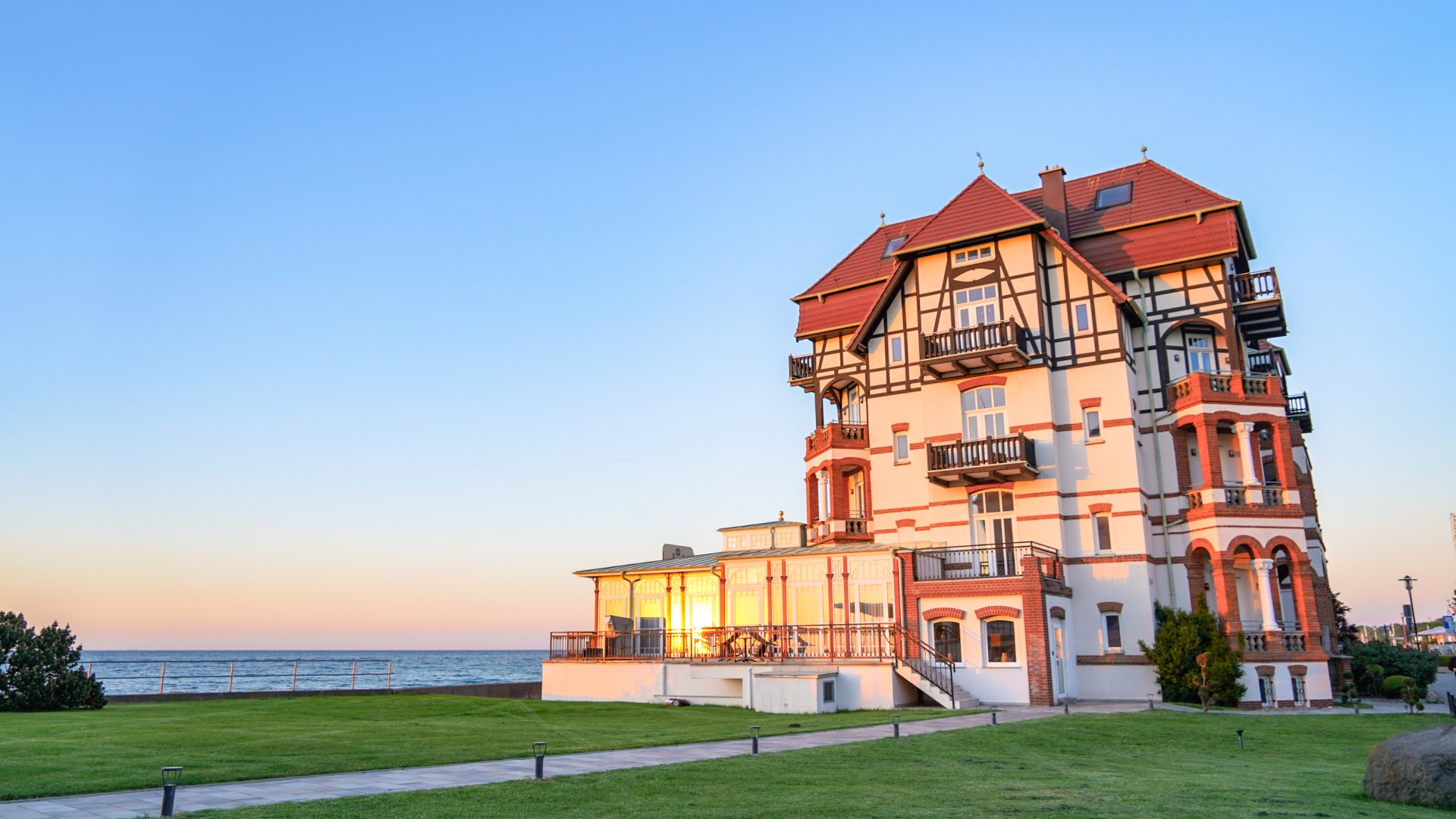 Historisches Geb&auml;ude im B&auml;derarchitekturstil in K&uuml;hlungsborn, mit Fachwerk und Balkonen, im Abendlicht vor der Ostsee.