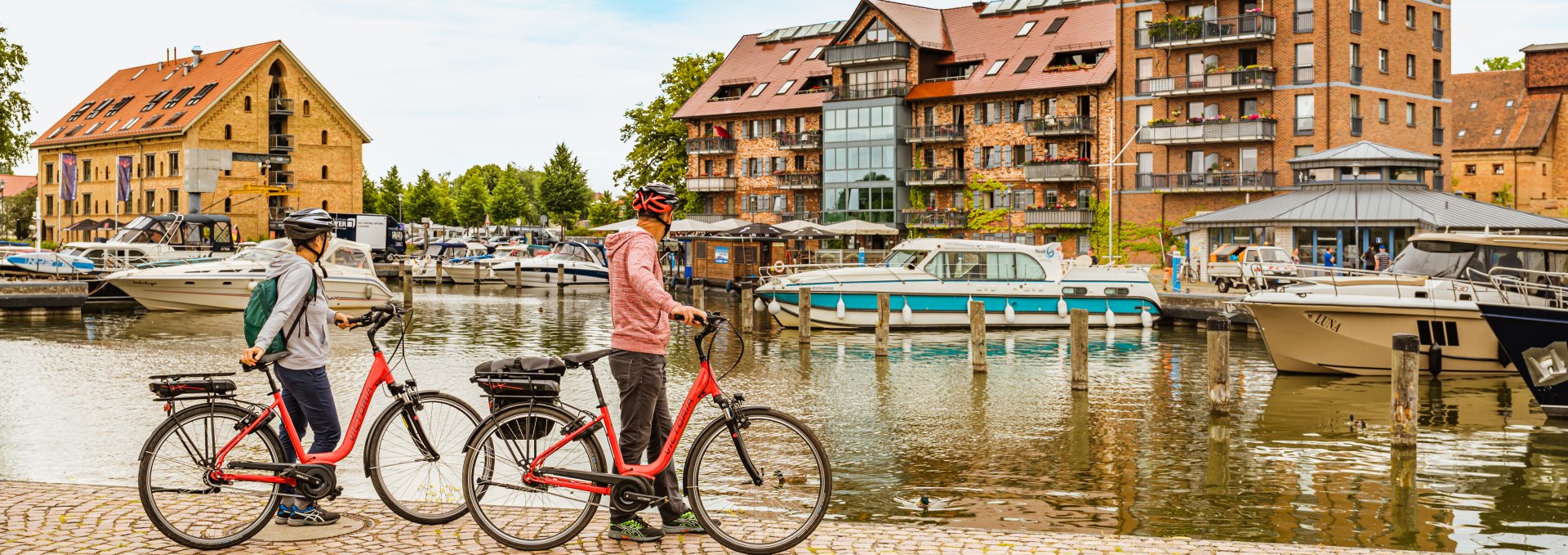 Der Hafen der Residenzstadt Neustrelitz - an diesem steht ein Paar mit Rädern. // Hier treffen sich Rad- und Bootstouristen, im Hafen der Residenzstadt Neustrelitz // © MV-T/Tiemann Der Hafen der Residenzstadt Neustrelitz - an diesem steht ein Paar mit Rädern.