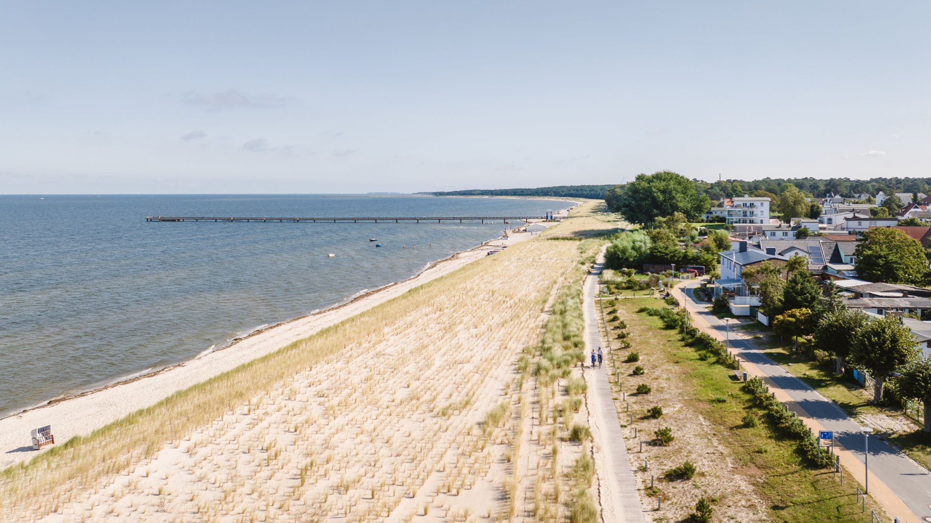 Weitl&auml;ufiger Sandstrand in Lubmin mit D&uuml;nen, Promenade und ruhiger Ostsee im Sonnenlicht des Greifswalder Boddens.