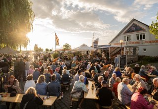 Live-Musik am Ribnitzer Fischhafen: volle B&auml;nke, Gespr&auml;che, Fischduft aus der R&auml;ucherei &ndash; Hafenflair bis in den Abend. // &copy; Ribnitzer Fischhafen / Hugo Scholz-Witzel