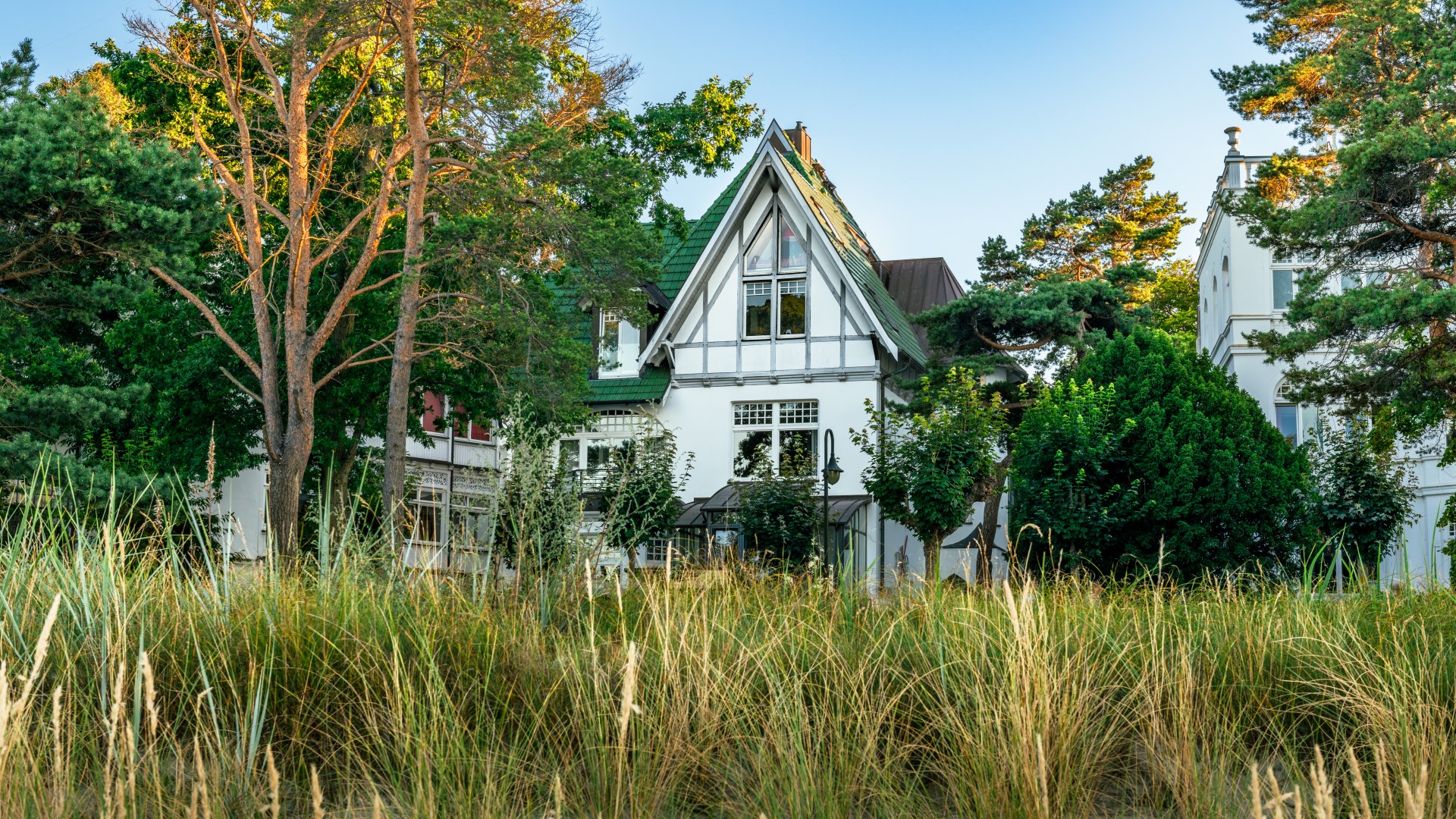 Het "Nixe" huis nestelt zich romantisch achter het duingras in Binz terwijl de zon ondergaat. // De "Nixe" duikt romantisch achter het duingras in Binz. // © MV-T/Tiemann Het "Nixe" huis nestelt zich romantisch achter het duingras in Binz terwijl de zon ondergaat.