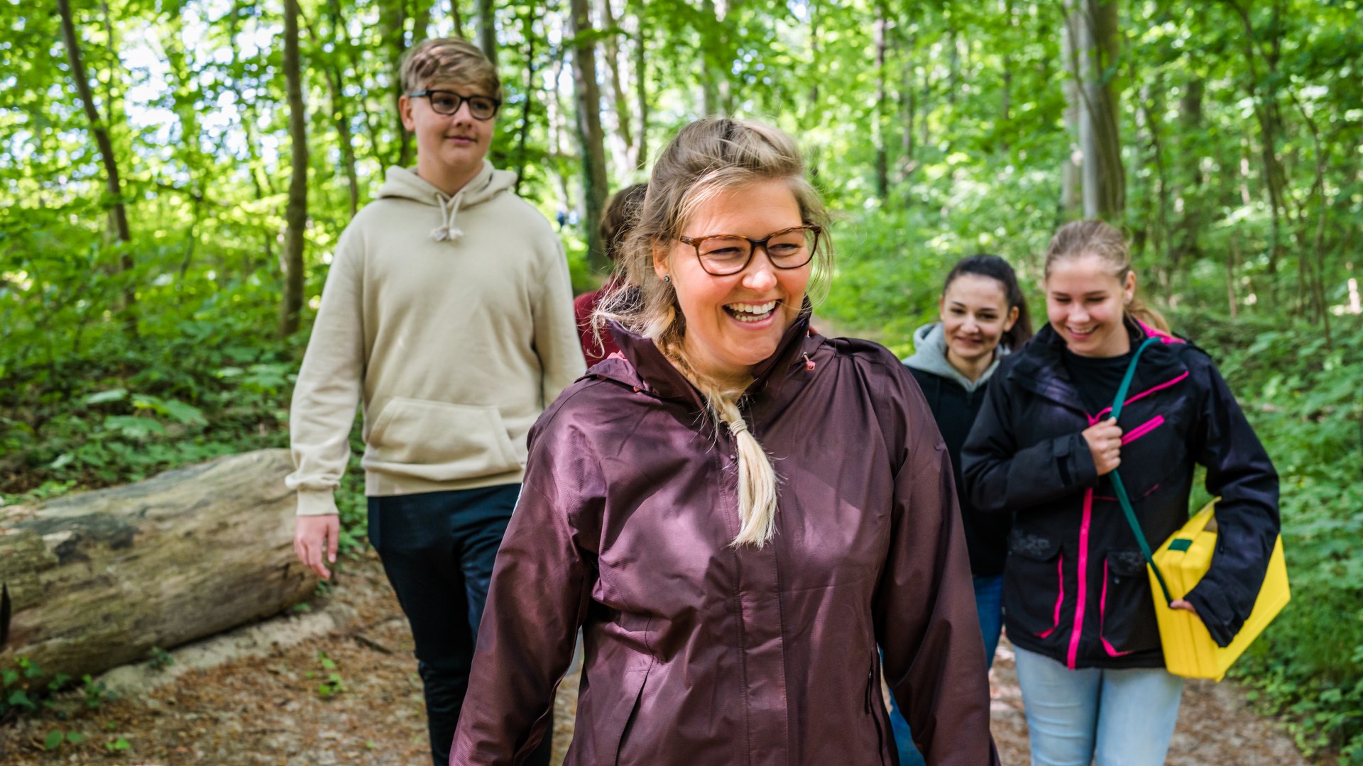 Die Meeresbiologin geht mit Kindern durch den Wald bei G&ouml;hren zu dem n&auml;chsten Standort f&uuml;r Forschende.