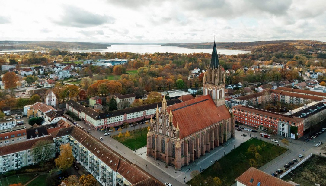 Et blik ud over Neubrandenburgs gamle bydel med udsigt til Konzertkirche og Tollensesee i baggrunden.