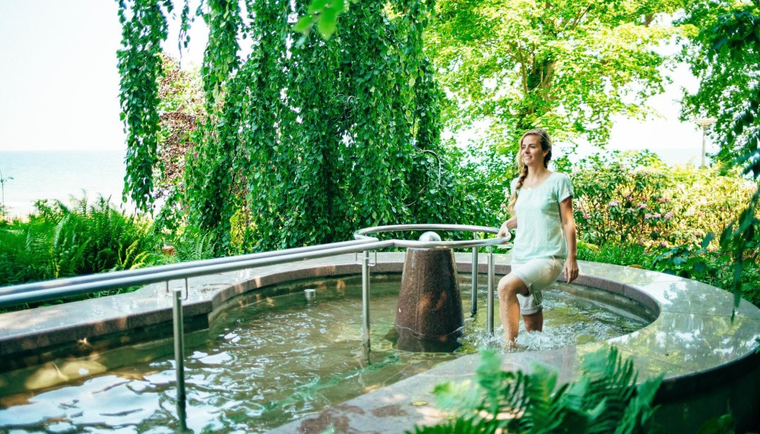 Eine Frau l&auml;uft in einem Kneipp-Wasserbecken umher.