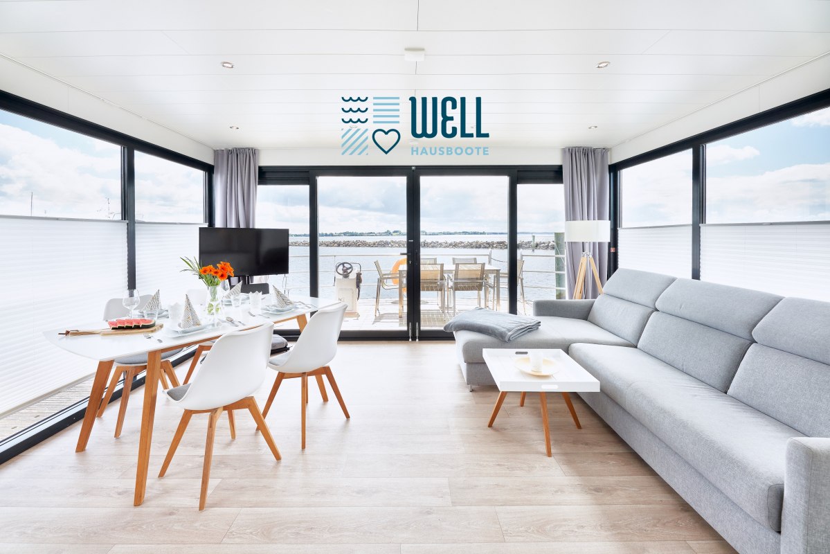Woon/eetkamer interieur woonboot met grote schuifdeur naar het boeg terras // &copy; Lars Franzen