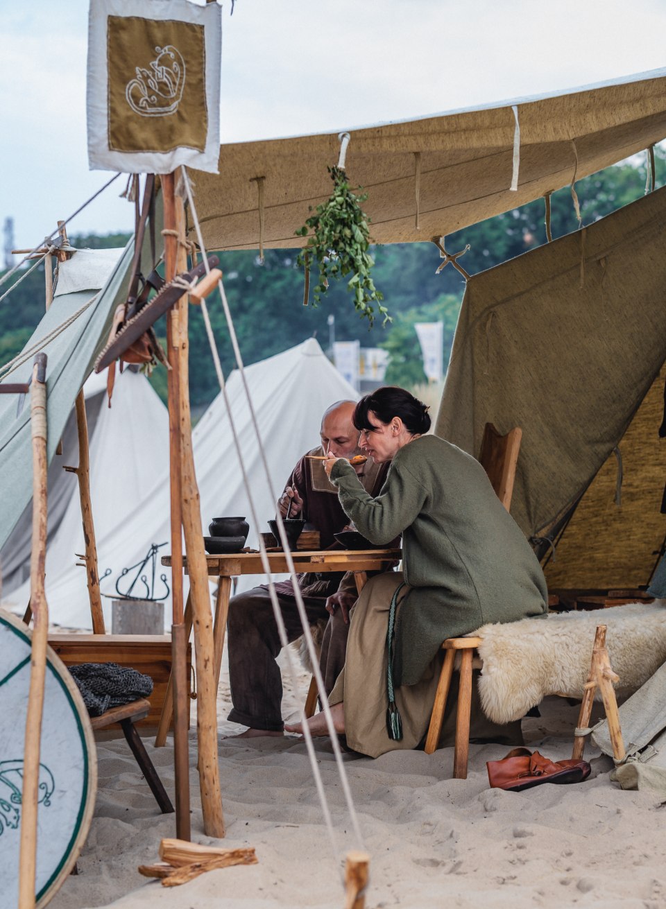 Wikinger beim Fest in G&ouml;hren essen unter ihrem Zelt zu Mittag am Strand.