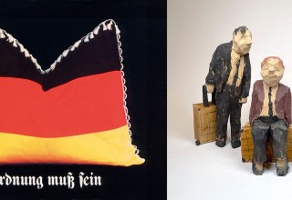 Klaus Staeck, &raquo;Ordnung muss sein&laquo;, 1987, Plakat, DIN-A1, 84.0 x 59.4 cm Georg Schulz, &raquo;Koffertr&auml;ger&laquo;, 2023, Holzskulptur, 25 cm // &copy; Staeck / Schulz