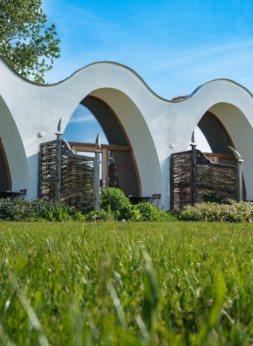 Strohhäuser und Lehmhäuser im Wangeliner Garten die in einander übergehen. // Die nachhaltigen Stroh- und Lehmhäuser wurden 2011 gemeinsam mit Gernot Minke, dem Pionier des ökologischen Bauens, errichtet. Für diesen besonderen Bau wurde eigens eine Maschine entwickelt. // © MV-T/Tiemann Strohhäuser und Lehmhäuser im Wangeliner Garten die in einander übergehen.