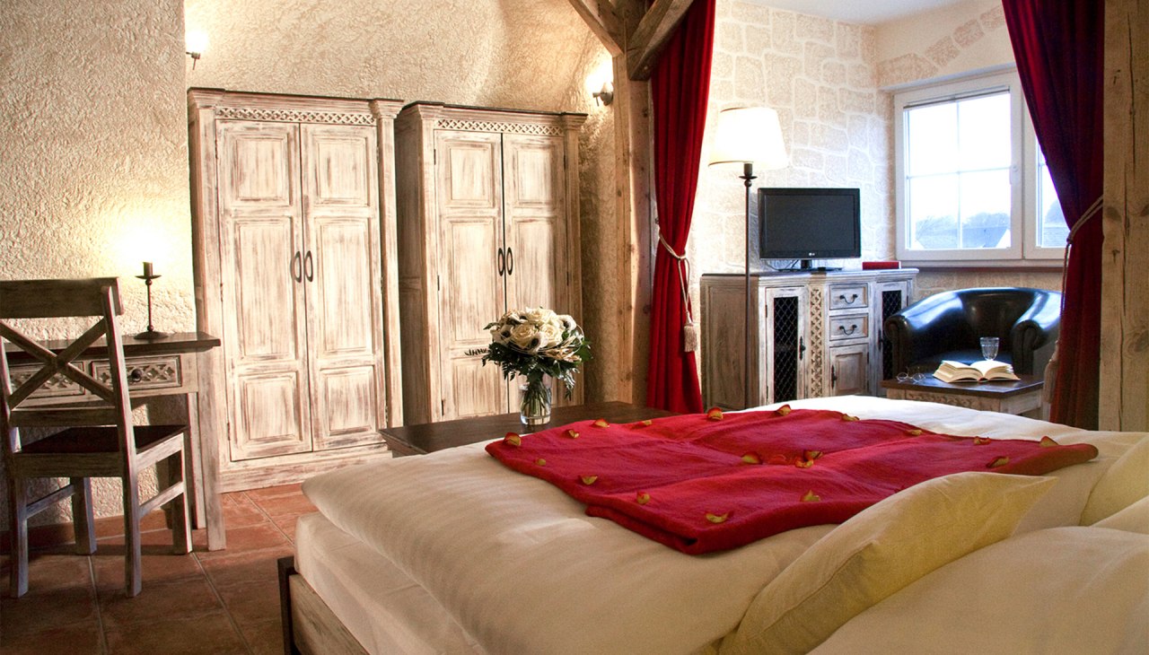 “Kastell GiebelStube Romantik-Traum”(DZ für max. 2 Personen, keine Kinder)Romantik Stil:Holzbalkenbett oder gotisches Metallbett. Erker mit Sesseln/Sofa.32? / 81cm LED-TV mit Radio. Schreibtisch.Du & WC. Kosmetikspiegel & Haartrockner.ca. 25 m² im Dachgeschoss im Haus Kastell., © BinzHotel.de/Eigentümer/WAECHTER “Kastell GiebelStube Romantik-Traum”(DZ für max. 2 Personen, keine Kinder)Romantik Stil:Holzbalkenbett oder gotisches Metallbett. Erker mit Sesseln/Sofa.32? / 81cm LED-TV mit Radio. Schreibtisch.Du & WC. Kosmetikspiegel & Haartrockner.ca. 25 m² im Dachgeschoss im Haus Kastell., © BinzHotel.de/Eigentümer/WAECHTER