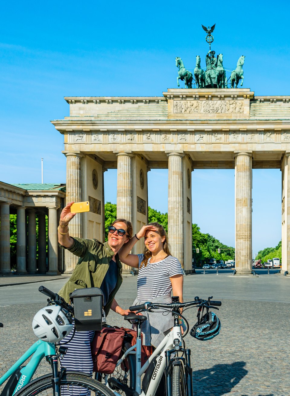 Mutter und Tochter mit Fahrrädern machen ein Selfie vor dem Brandenburger Tor