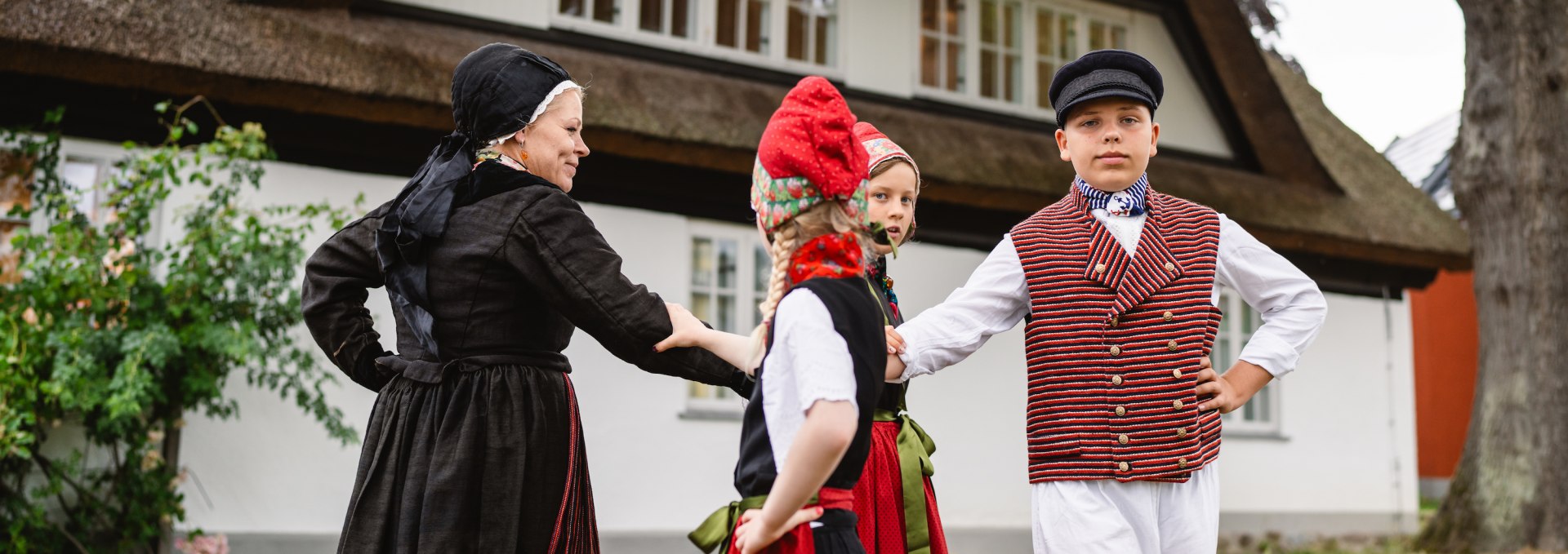 Kindertrachtengruppe in Göhren vor dem Heimatmuseum tanzen // Ina Stöckmann (links) beim Tanz mit einigen Jungen und Mädchen von der Kindertrachtengruppe in Göhren // © MV-T/Gross Kindertrachtengruppe in Göhren vor dem Heimatmuseum tanzen