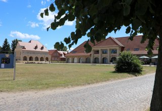 Het koetshuis van "Schloss Stolpe" met restaurant. Op de achtergrond delen van de westelijke vleugel die van het kasteel is afgescheiden. // © Dr. Lüling, GF SaH Het koetshuis van "Schloss Stolpe" met restaurant. Op de achtergrond delen van de westelijke vleugel die van het kasteel is afgescheiden. // © Dr. Lüling, GF SaH