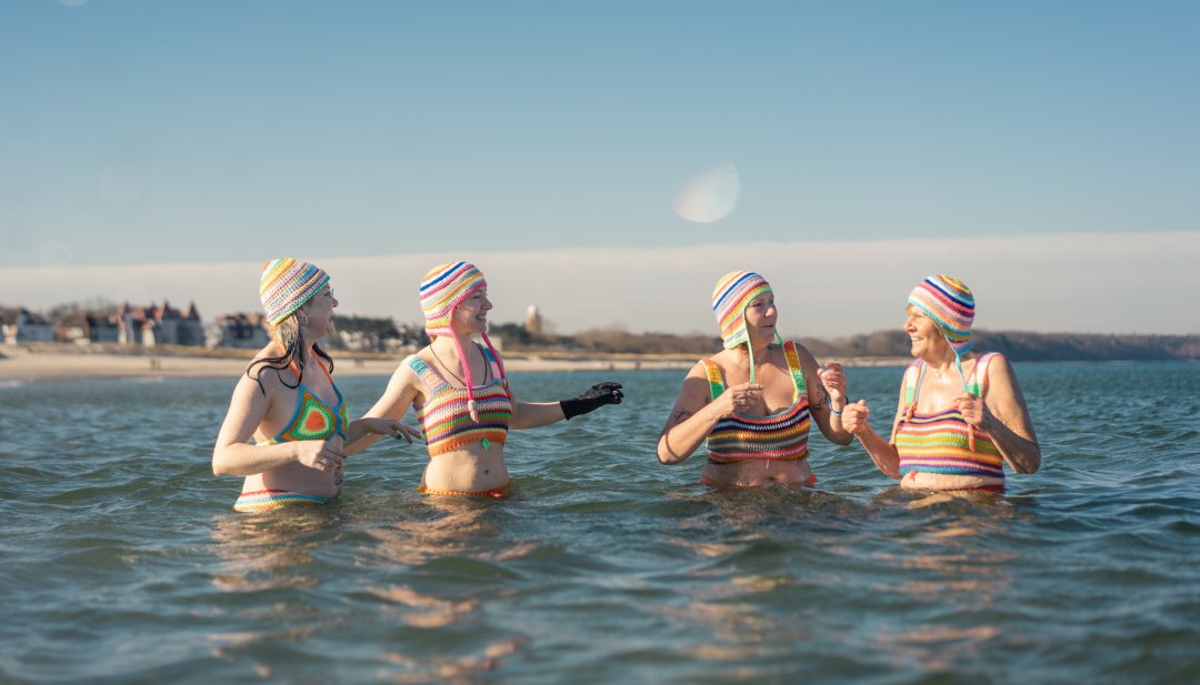 Vier Frauen in bunten Strickbikinis beim Winterbaden in der Ostsee vor der K&uuml;ste Mecklenburg-Vorpommerns.