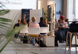Workshopgruppe von hinten im InnovationPort Wismar vor Whiteboard und Rollup // © InnovationPort Wismar Workshopgruppe von hinten im InnovationPort Wismar vor Whiteboard und Rollup // © InnovationPort Wismar