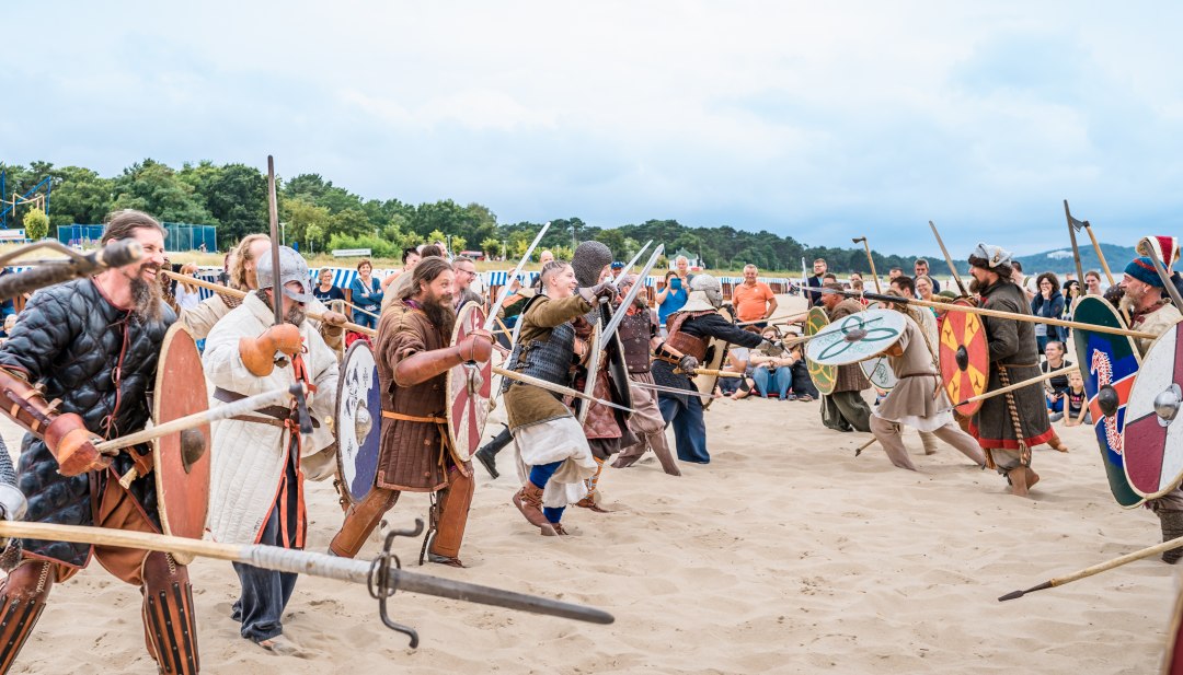 Als Wikinger verkleidete Personen laufen auf einander zu am Strand von Göhren // Die „Strand-Schlachten“ zwischen den Sippen gehören zu den Höhepunkten des Göhrener Wikingerfests // © MV-T/Tiemann Als Wikinger verkleidete Personen laufen auf einander zu am Strand von Göhren
