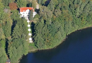 Luftbild des Schlosses Drosedow mit Park und See // &copy; Schloss Drosedow