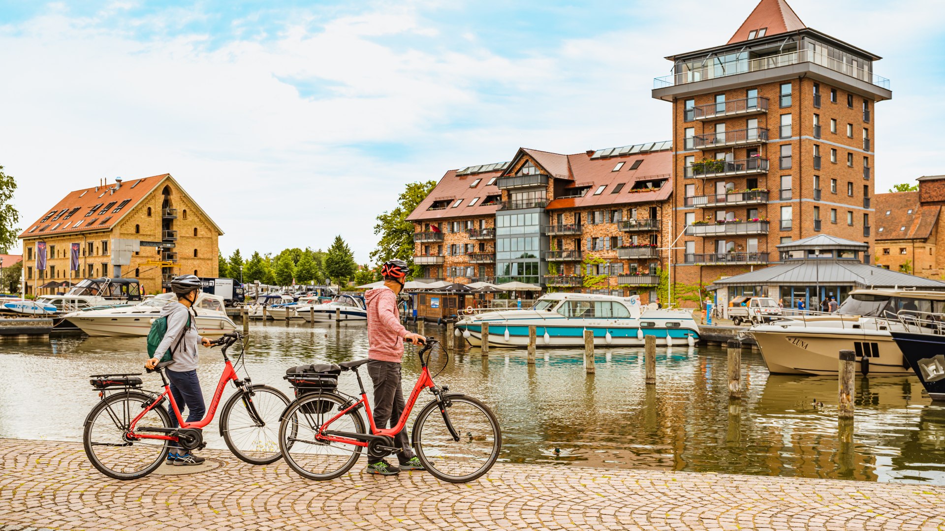 Hier treffen sich Rad- und Bootstouristen, im Hafen der Residenzstadt Neustrelitz, © TMV/Tiemann Der Hafen der Residenzstadt Neustrelitz - an diesem steht ein Paar mit Rädern.